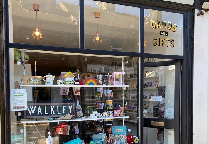 An exterior shot of The Walkley Press, who sell cards and gifts. There is a bright and cheerful window display.