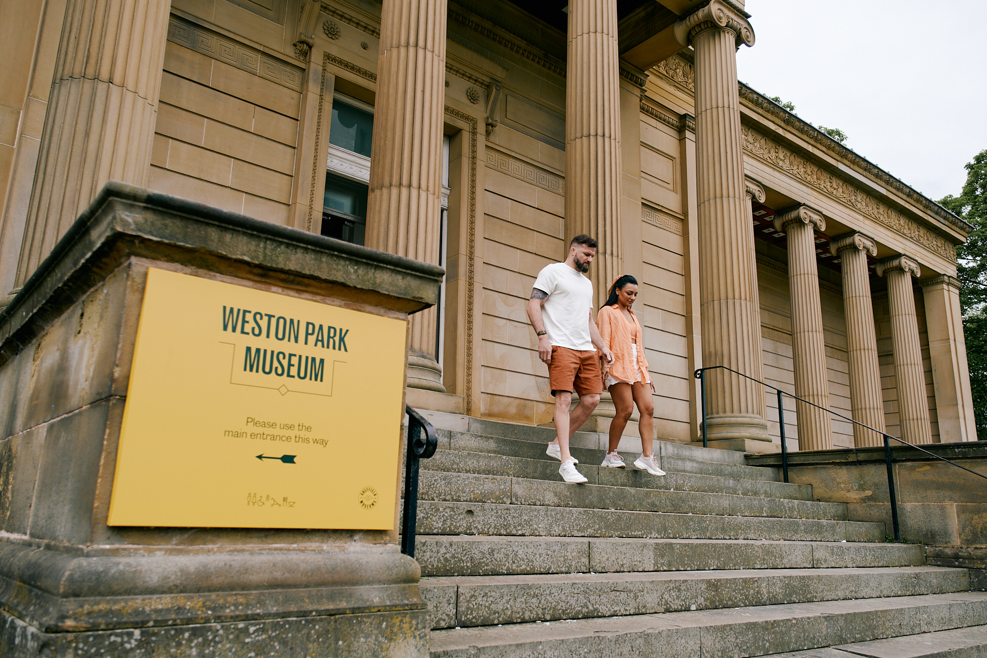 A couple walk down the steps outside the Weston Park Museum in Sheffield.