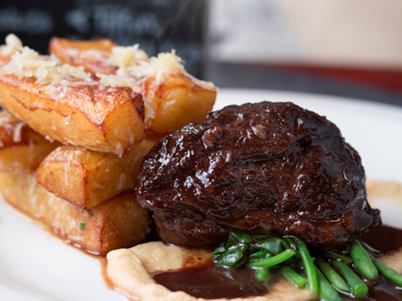 A cut of meet with chunky chips on a plate.