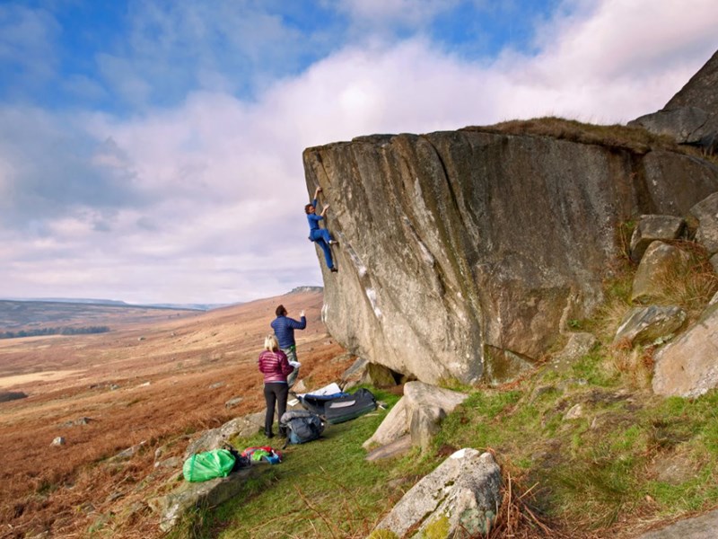 A group of people climbing a small rock face.