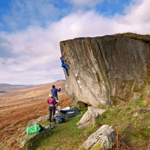 A group of people climbing a small rock face.
