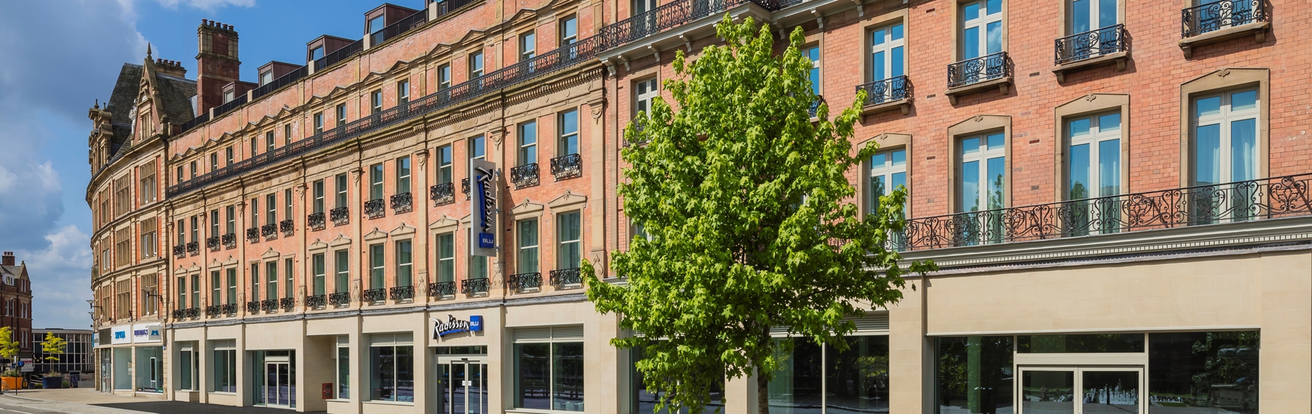 Exterior of the Radisson Blu hotel with trees in front.
