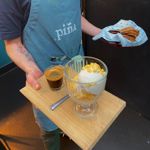 A member of Piña staff carrying food and drinks to a table.