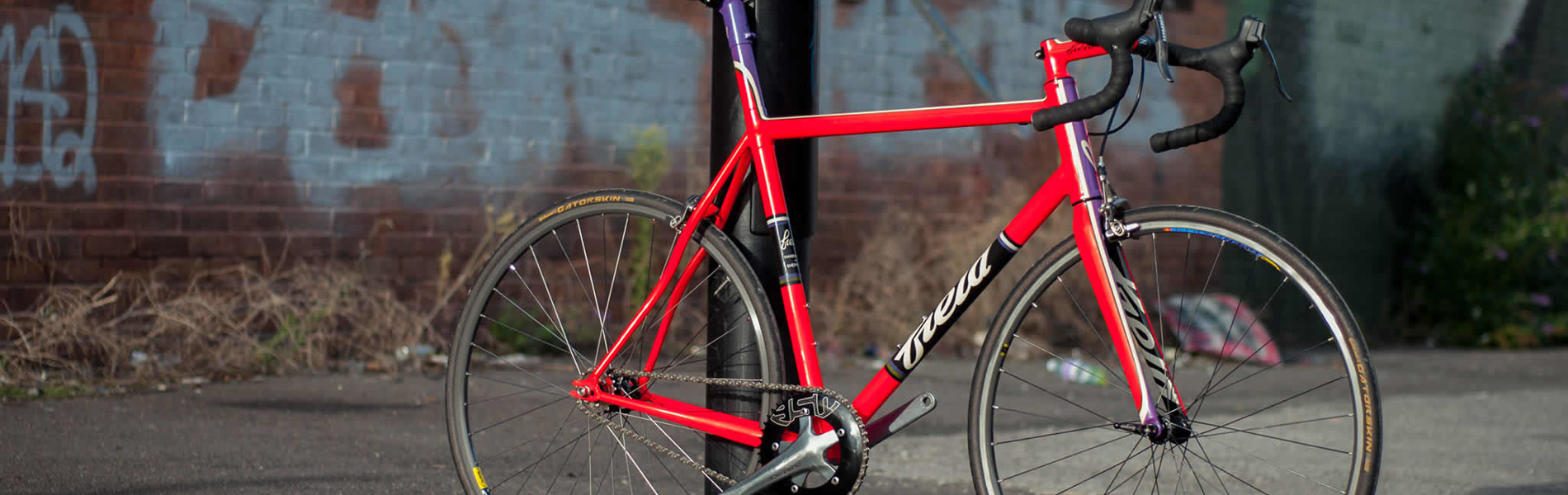 A classic racing bike leaning against a lamppost.