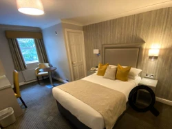 Bedroom at Cubley Hall with double bed, bedside tables, and lamp.