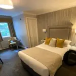 Bedroom at Cubley Hall with double bed, bedside tables, and lamp.