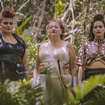Three people stood in a jungle