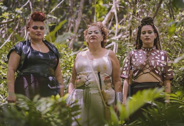 Three people stood in a jungle