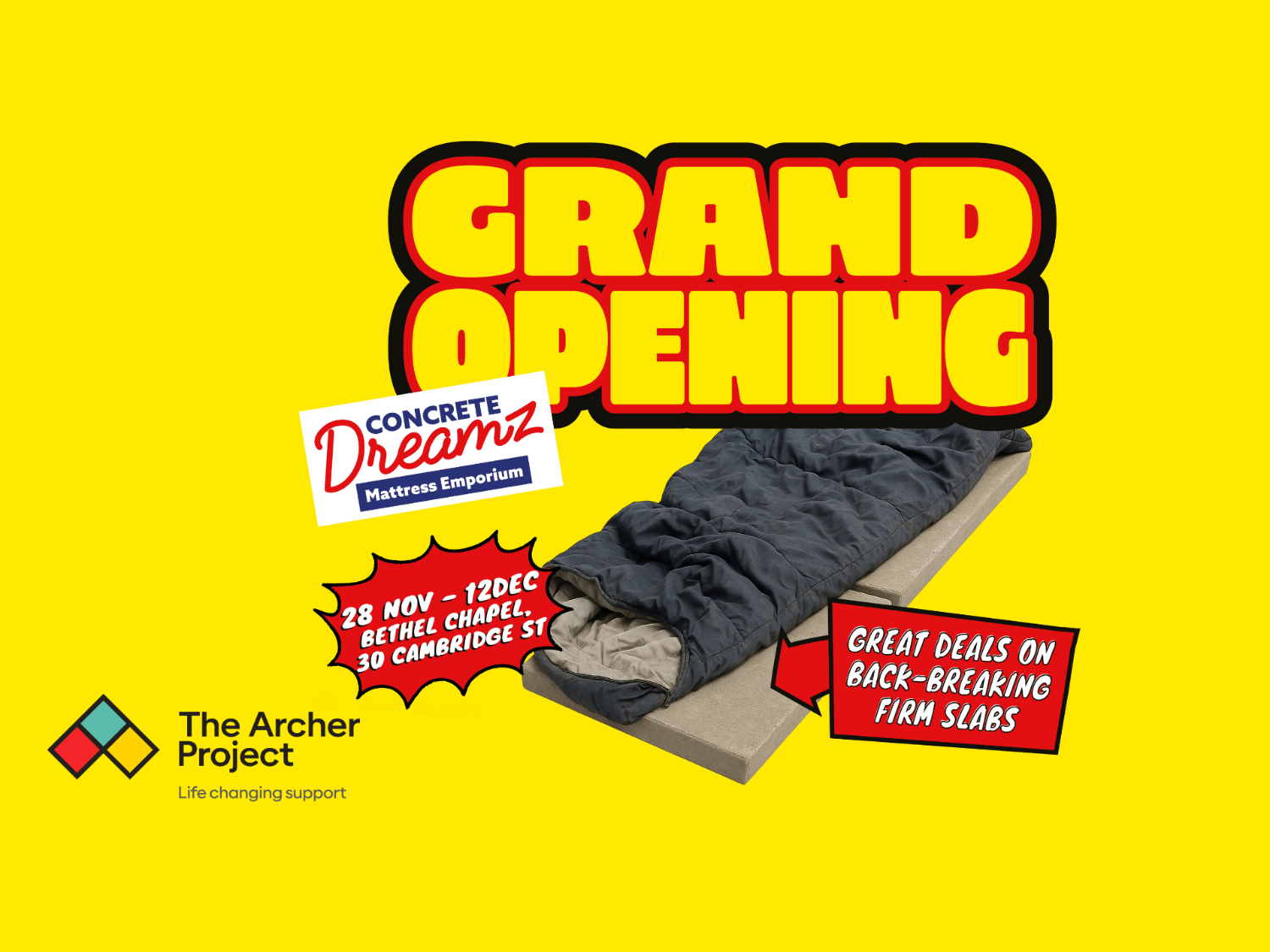Bright yellow poster with bold red and black text reading “Grand Opening.” Below, an image of a sleeping bag on a concrete slab with a sign saying “Great deals on back-breaking firm slabs.” Another sign reads “Concrete Dreamz Mattress Emporium.” Event details: 28 Nov – 12 Dec at Bethel Chapel, 30 Cambridge St. Bottom left shows The Archer Project logo with tagline “Life changing support.”