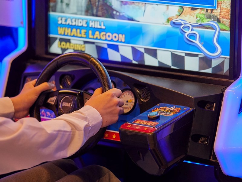 A person playing a driving game at The National Videogame Museum.