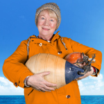  A person in an orange rain coat hold two boat fenders.