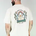 A man stands with his back to the camera, wearing a baseball bat, a white t-shirt with a colourful back print and black trousers. The design on the shirt is 2 mountains with smiling faces hugging. Above them is a smiley sun, above which the mountains are holding up a rainbow. Either side of this are two smiling daisies. Above the image are the words 'Nature is nice'.