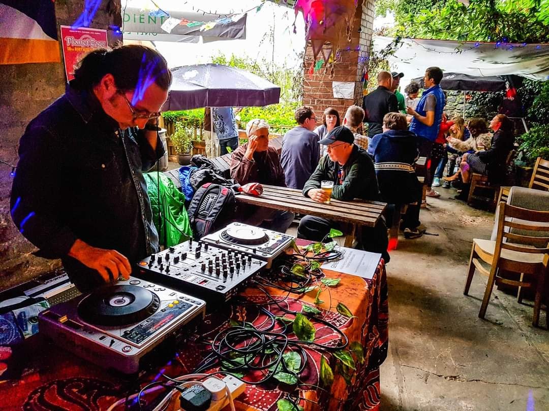 A DJ at the decks in the outdoor seating area at Jabbarwocky.