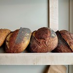 A shelf full of freshly baked bread at Bench La Cave .