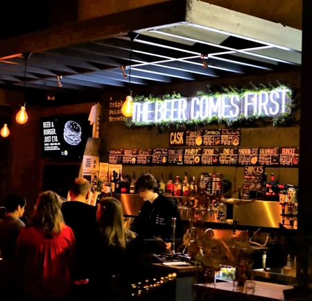 A crowd of people enjoying at night out at Triple Point Brewery.