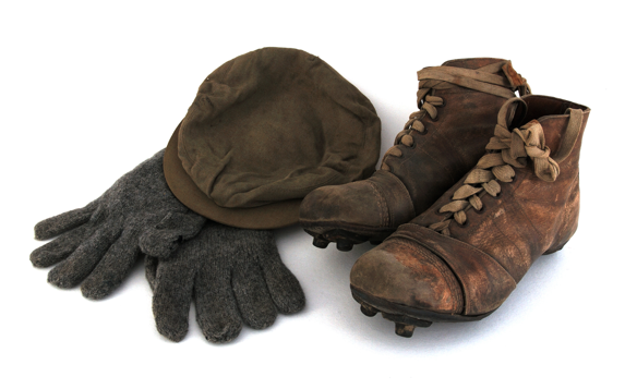 A pair of old football boots, a flat cap and a pair of gloves.