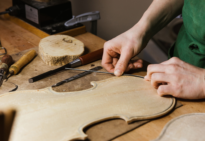A close-up of someone making a violin.