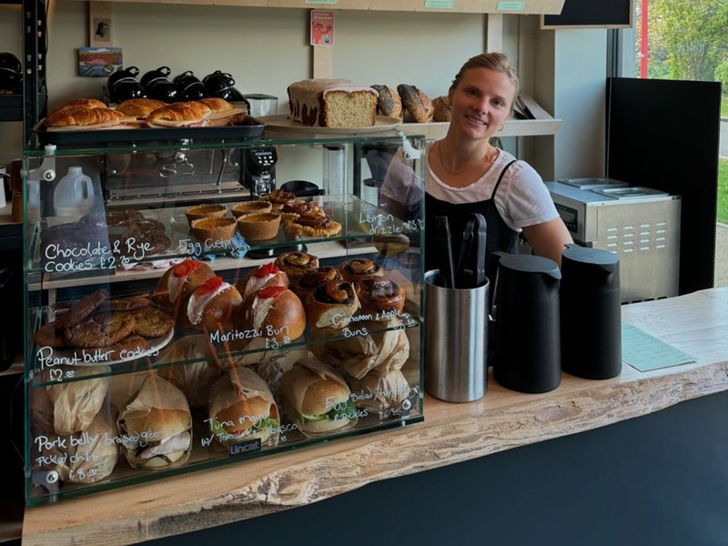 A member of staff behind the counter at Bench La Cave .