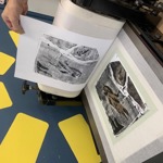 Close up of a person leafing through a book of prints.