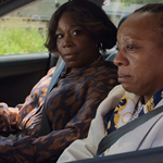 Two women of African heritage sitting in a car.
