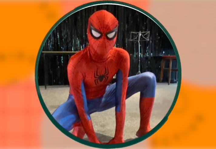 A person dressed as Spiderman, crouching on the floor.