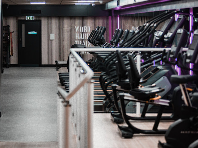 Gym area with lots of treadmills in a row.