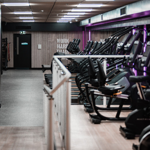 Gym area with lots of treadmills in a row.