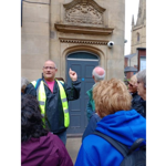 A tour guide talks to a group of people on a tour in Sheffield.