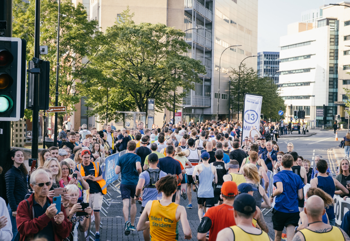 Group of people taking part in Sheffield Half Marathon, running along Arundel Gate.