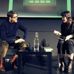 Two people, on a stage, having a discussion.