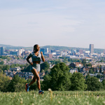 Runner in Meersbrook Park with cityscape view in the background