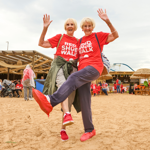 A couple wearing Red Shoe Walk t-shirts and their own red shoes!