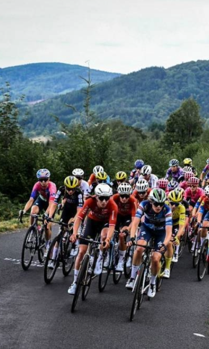A large group of female road cyclists cycle through the country side, as part of the Tour de France Femme avec Zwift.