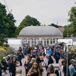 A large crowd of people at the Art In The Gardens event taking place in Sheffield Botanical Gardens.