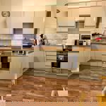 Small but functional kitchen at Homely Apartments – Figtree featuring stove, sink, and storage