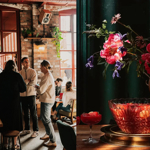 A split image of people standing and chatting in a venue and a flower arrangement.
