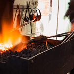 A piece of metal is being heated in a forge, ready to be worked.
