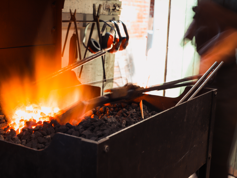 A piece of metal is being heated in a forge, ready to be worked.