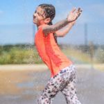 A child playing in a water spray.
