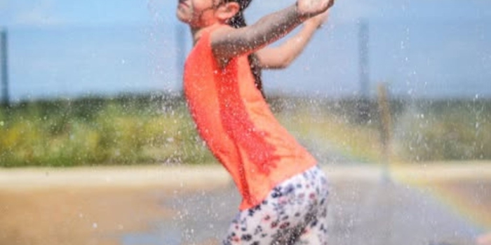 A child playing in a water spray.