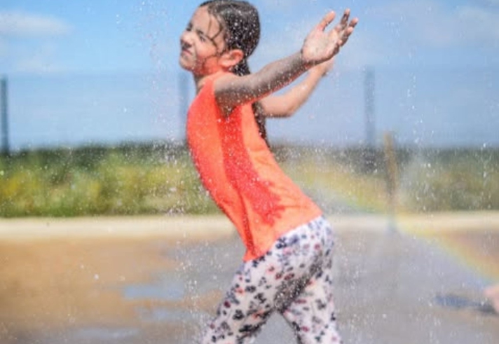 A child playing in a water spray.