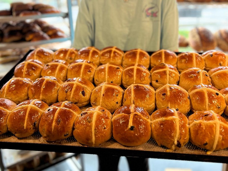 A tray of hot cross buns, fresh out of the oven.