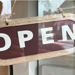 A wooden Open sign hanging in the door at Gills & Co.