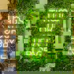 A green neon sign that reads 'This is our happy place' on the wall at S17 Coffee Shop & Bistro.