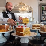 A member of staff cuts a slice of cake at Jameson's Tea Room.