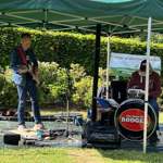 A band playing live in a park under a gazebo.