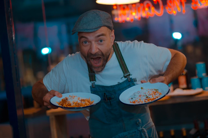 A chef holding two plates of food that are ready to go.