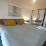 Double bed featuring soft furnishings and decorative cushions.