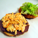 A bagel being prepared with fillings.