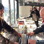 Two men looking through crates of vinyl LPs at a record fair.